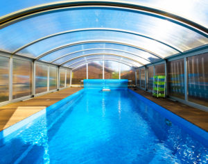 Swimming Pool With Blue Water And Transparent Plastic Tent. An example of modern plastic outdoor structures