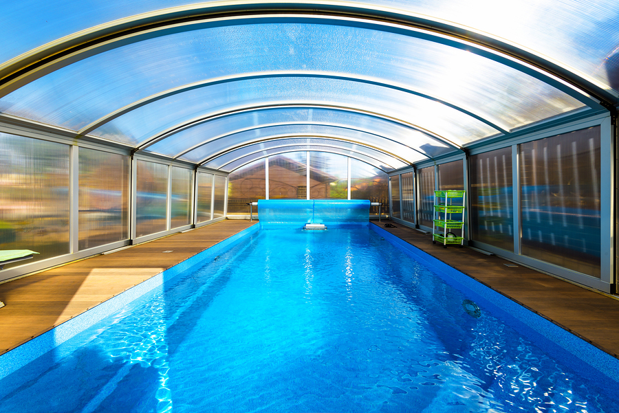 Swimming Pool With Blue Water And Transparent Plastic Tent. An example of modern plastic outdoor structures