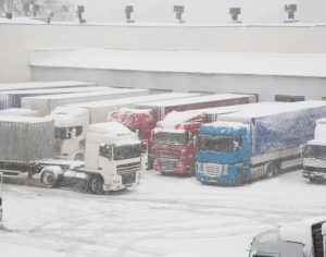 Trucks Loading At Warehouse And Transport Terminal. Inclement holiday weather