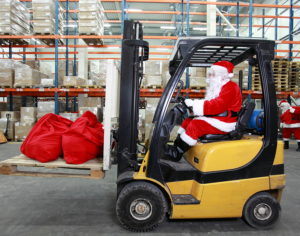 Rush hours before Christmas. Santa Claus as a forklift operator; holiday season supply chain