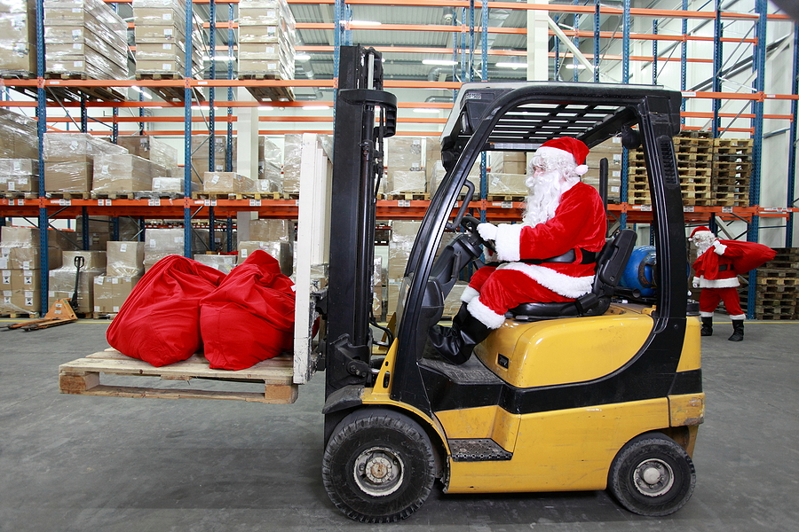 Rush hours before Christmas. Santa Claus as a forklift operator; holiday season supply chain