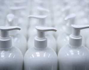 White plastic soap bottles in rows at assembly line; kitting services